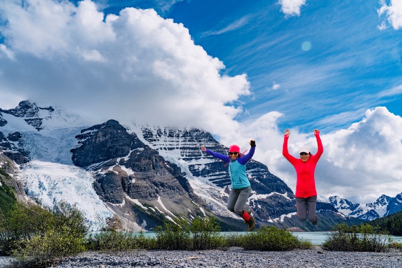 A group of people jumping in the air with mountains in the background

Description automatically generated with low confidence