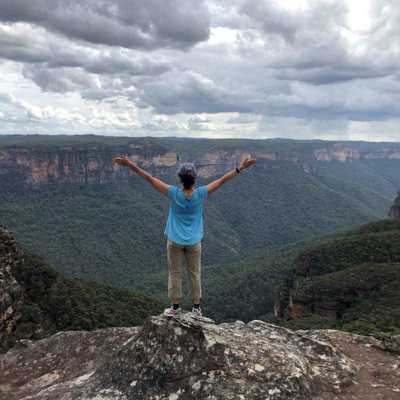 A person standing on a rock with his arms raised

Description automatically generated with low confidence